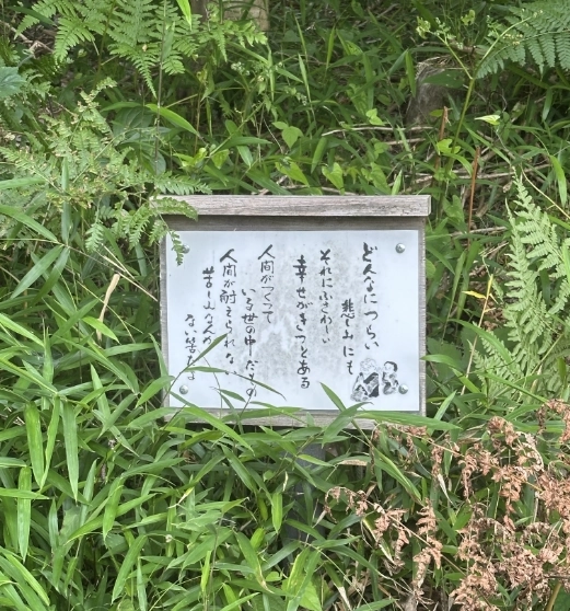 草むらに立つ言葉が書かれた案内板