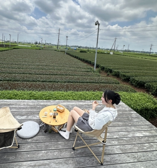 茶畑を望むデッキでひと息つく人